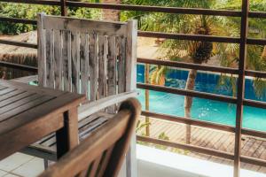 a wooden chair sitting on a balcony with a swimming pool at Pipa Panorama Flats&Apartamentos in Pipa +91 photos