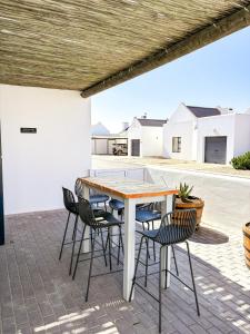 a patio with a wooden table and chairs at Arc On Ray 31 in Britannia Bay