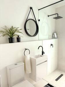 a white bathroom with a toilet and a mirror at Arc On Ray 31 in Britannia Bay +40 photos
