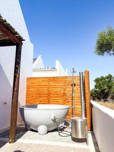 a bath tub sitting on a patio next to a fence at Arc On Ray 31 in Britannia Bay