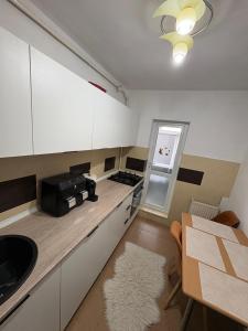 a kitchen with a counter and a table and a stove at NiC Apartment in Râmnicu Vâlcea