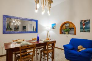 a dining room with a table and a blue chair at Dimora Santamarea in Torre Santa Sabina