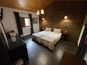 a bedroom with a white bed and a wooden floor at Rilhadas Casas de Campo in Fafe +154 photos