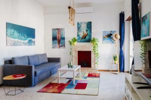 a living room with a blue couch and a fireplace at Dimora Santamarea in Torre Santa Sabina