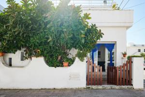 a white house with a fence and a plant at Dimora Santamarea in Torre Santa Sabina