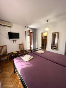 a large purple bed in a room with a tv at Rooms Villa Desa in Budva