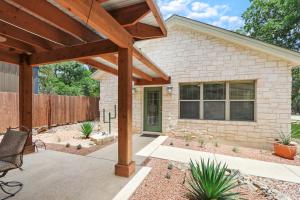 a stone house with a wooden pergola at Three Sisters - Casita 2 in Wimberley +17 photos
