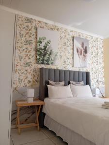 a bedroom with a king sized bed and a side table at Naliya Guest house in Cape Town +26 photos
