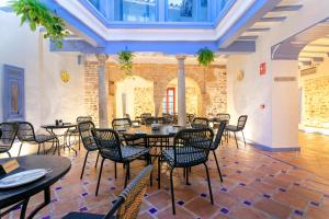 a restaurant with tables and chairs in a room at CSE The Old House Marbella in Marbella