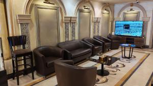 a waiting room with leather chairs and a flat screen tv at Al Fursan Al Mutahida Hotel فندق الفرسان المتحده in Jeddah