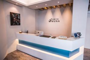 a reception desk with a sign that reads ultra muna at MUNA Hostel in Hualien City