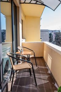 a table and chairs on the balcony of a building at Cozy and Stylish Apartment 3 in Stara Zagora