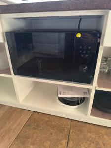 a microwave oven sitting inside of a cabinet at Large apartment with parking in Palanga
