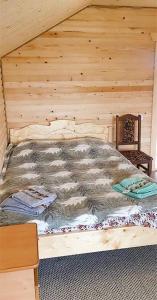 a bed in a cabin with a wooden wall at Топірець in Vorokhta