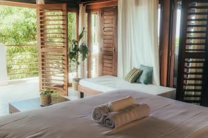 a bedroom with two beds and a large window at Pipa Panorama Flats&Apartamentos in Pipa