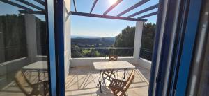 a balcony with a table and chairs on a balcony at Villa Avra - Apartment Hydra in Asgourou +4 photos