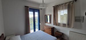 a bedroom with a bed and a window at Villa Avra - Apartment Hydra in Asgourou