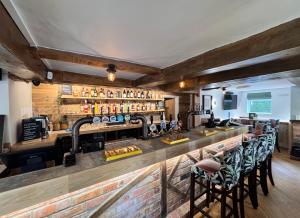 a bar in a restaurant with a counter and chairs at The World's End in Lowdham