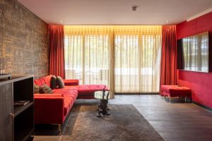 a living room with a red couch and red curtains at Van der Valk Hotel Assen in Assen