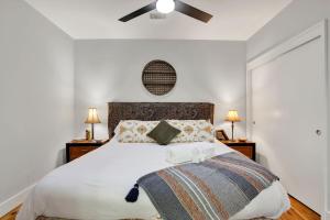 a bedroom with a large bed with a ceiling fan at Above Broughton St 3002 in Savannah +29 photos