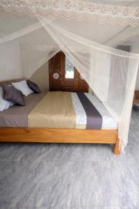 a bed with a canopy in a room at Rusal Haven in Rubavu
