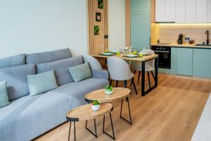 a living room with a blue couch and a kitchen at Cozy and Stylish Apartment 3 in Stara Zagora