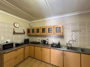 a kitchen with a sink and a clock on the wall at Turn and slip in Bloemfontein