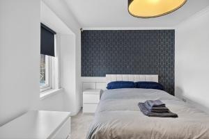 a bedroom with a bed with a black accent wall at Seaside Snug in Largs