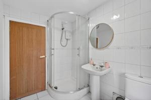 a bathroom with a shower and a sink and a mirror at Seaside Snug in Largs +13 photos