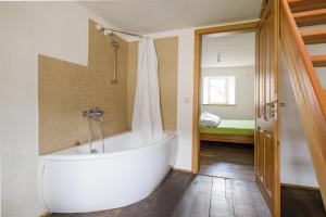 a bath tub in a bathroom with a bedroom at Nengshof Ferienhaus Gänseblümchen in Wißmannsdorf
