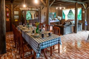 a dining room with a table and a couch at Sítio Temporada in Guabiruba