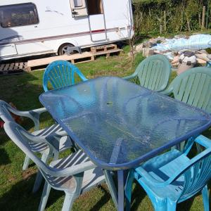 a blue table with three chairs and a trailer at CaraCaux in Le Torp-Mesnil