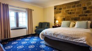 a bedroom with a bed and a chair and a window at Santo's Higham Farm Hotel in Alfreton +42 photos