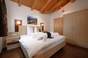 a bedroom with a large bed with white sheets at Apart Marie-Therese in Umhausen