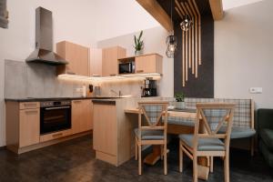a kitchen with wooden cabinets and a table with chairs at Apart Marie-Therese in Umhausen