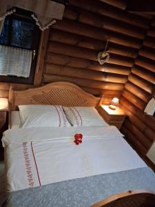 a bedroom with a bed with a red flower on it at Meseház Apartman in Zalalövő