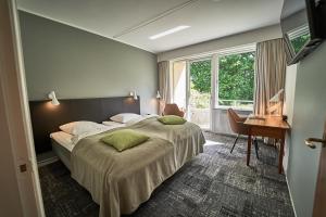 a bedroom with a large bed with a desk and a desk at Gl Skovridergaard in Silkeborg