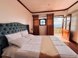 a bedroom with a large bed with a large window at Andina Amazon Lodge in Chachapoyas
