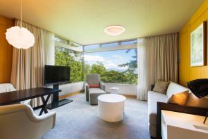 a living room with a large window and a couch at The Green Leaf Niseko Village, Tapestry Collection by Hilton in Niseko