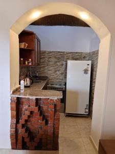 a kitchen with a brick counter and a refrigerator at Nur al Nil Garden House in Luxor +30 photos