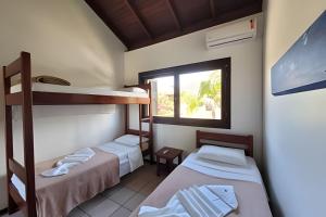a room with two bunk beds and a window at Casa Morrinhos 17 in Garopaba