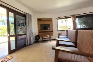 a living room with a couch and a television at Casa Morrinhos 17 in Garopaba