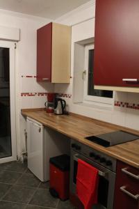 a kitchen with red cabinets and a wooden counter top at Fair Trade Apartment in Düsseldorf