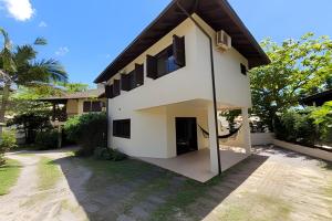 a white house with a black roof at Casa Morrinhos 17 in Garopaba