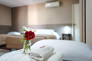 a hotel room with towels and a vase with a rose at Hotel de la Linda in Salta