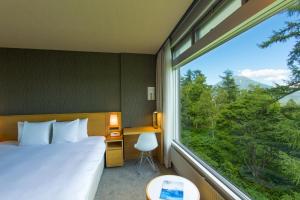 a bedroom with a bed and a large window at The Green Leaf Niseko Village, Tapestry Collection by Hilton in Niseko
