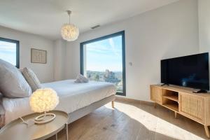 a bedroom with a bed and a flat screen tv at BELLEVUE 1, piscine, jacuzzi, sauna in Champcevinel +50 photos