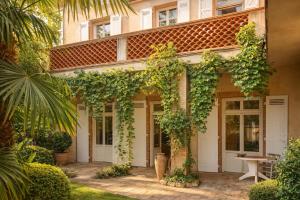 a house with a bunch of ivy growing on it at Chez ma poule in Moissac