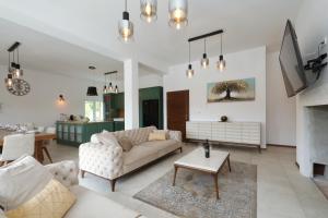 a living room with a couch and a table at Villa Demare with Heated Pool, Free EVC Station in Lovinac
