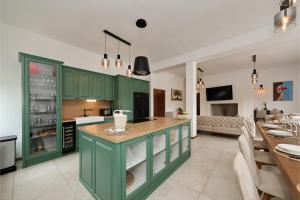 a kitchen with green cabinets and a living room at Villa Demare with Heated Pool, Free EVC Station in Lovinac